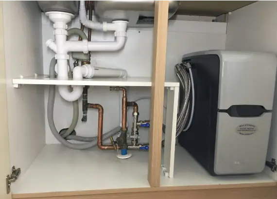 Water softener installed below a kitchen sink